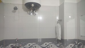 Een badkamer met een douche, een wastafel en een handdoekhouder.