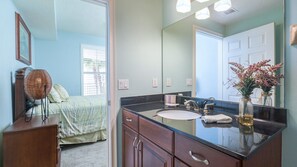 A bathroom with a large mirror, a sink, and a cabinet. - 306 St Maarten - Oceanfront Paradise (Daytona Beach Shores)