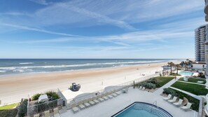 A beachfront hotel with a pool, lounge chairs, and a view of the beach and ocean. - 306 St Maarten - Oceanfront Paradise (Daytona Beach Shores)