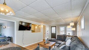 A modern living room with a sectional sofa, a wooden coffee table, and a TV mounted on the wall.