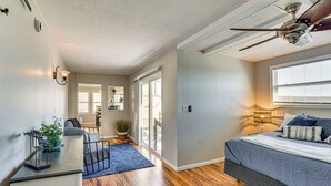 A bedroom with a bed, a desk, and a ceiling fan.