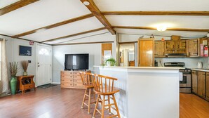 Une cuisine spacieuse avec des meubles de rangement en bois, un îlot central et un four encastré.