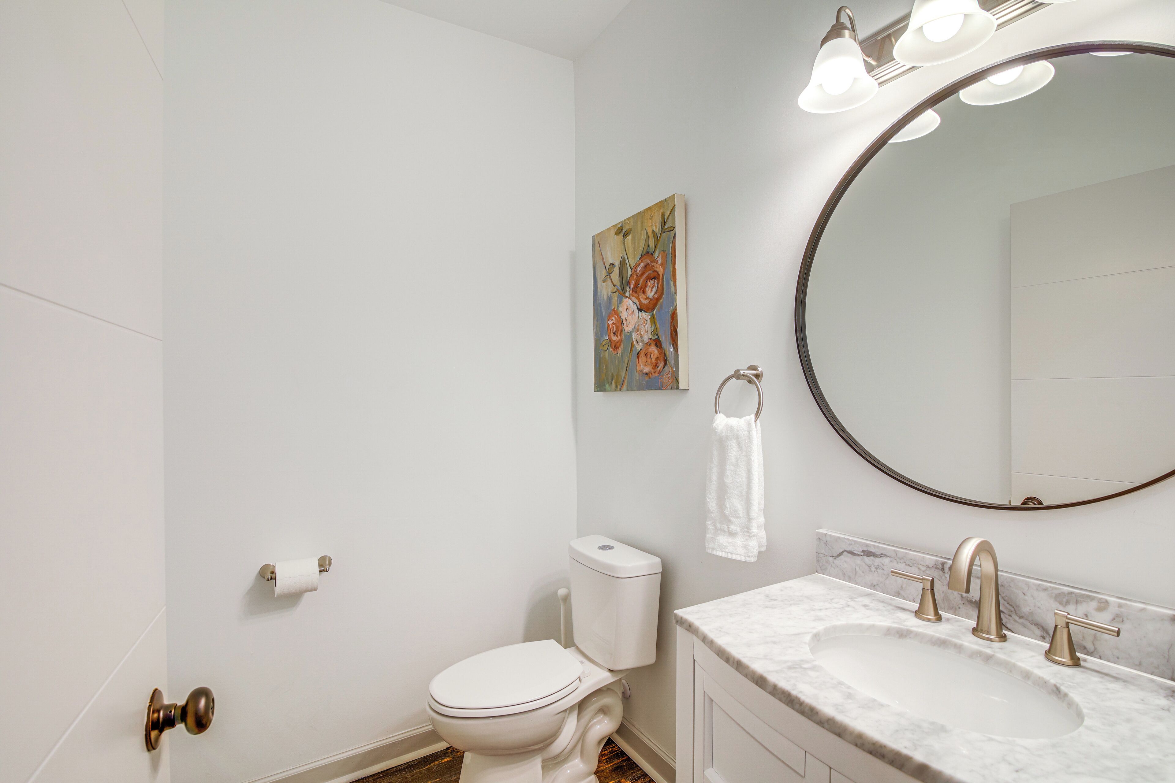 Une salle de bain avec des toilettes, un lavabo et un miroir.