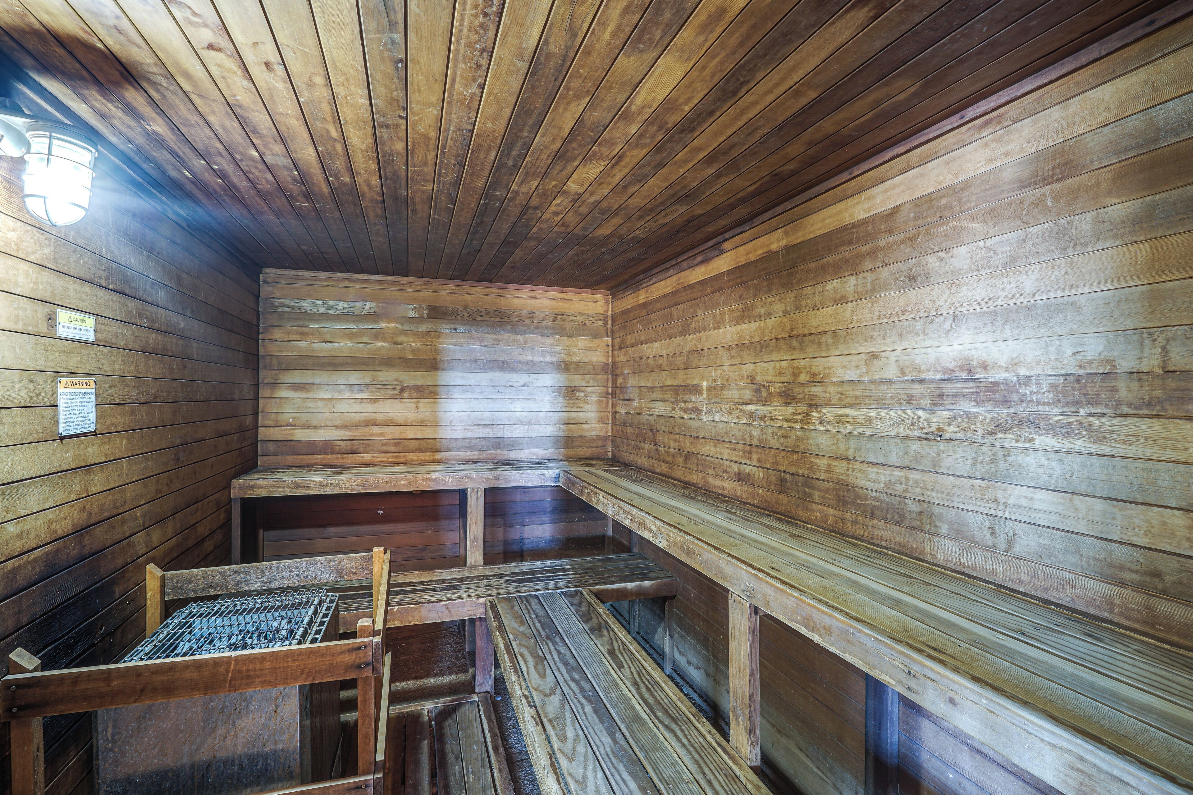 Un sauna avec des bancs en bois et un plafond incliné.