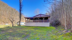 A cabin with a covered porch, surrounded by trees and a grassy area. - Near Riding Trails for Atvs: Cabin in Delbarton (Delbarton)