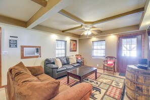 A living room with a sofa, armchair, and coffee table. There is a ceiling fan, a wooden barrel, and a door with windows. - Near Riding Trails for Atvs: Cabin in Delbarton (Delbarton)
