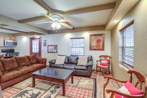 A living room with a brown leather sofa, a wooden coffee table, and a wooden rocking chair. There is a ceiling fan, a microwave, and a window with blinds. - Near Riding Trails for Atvs: Cabin in Delbarton (Delbarton)
