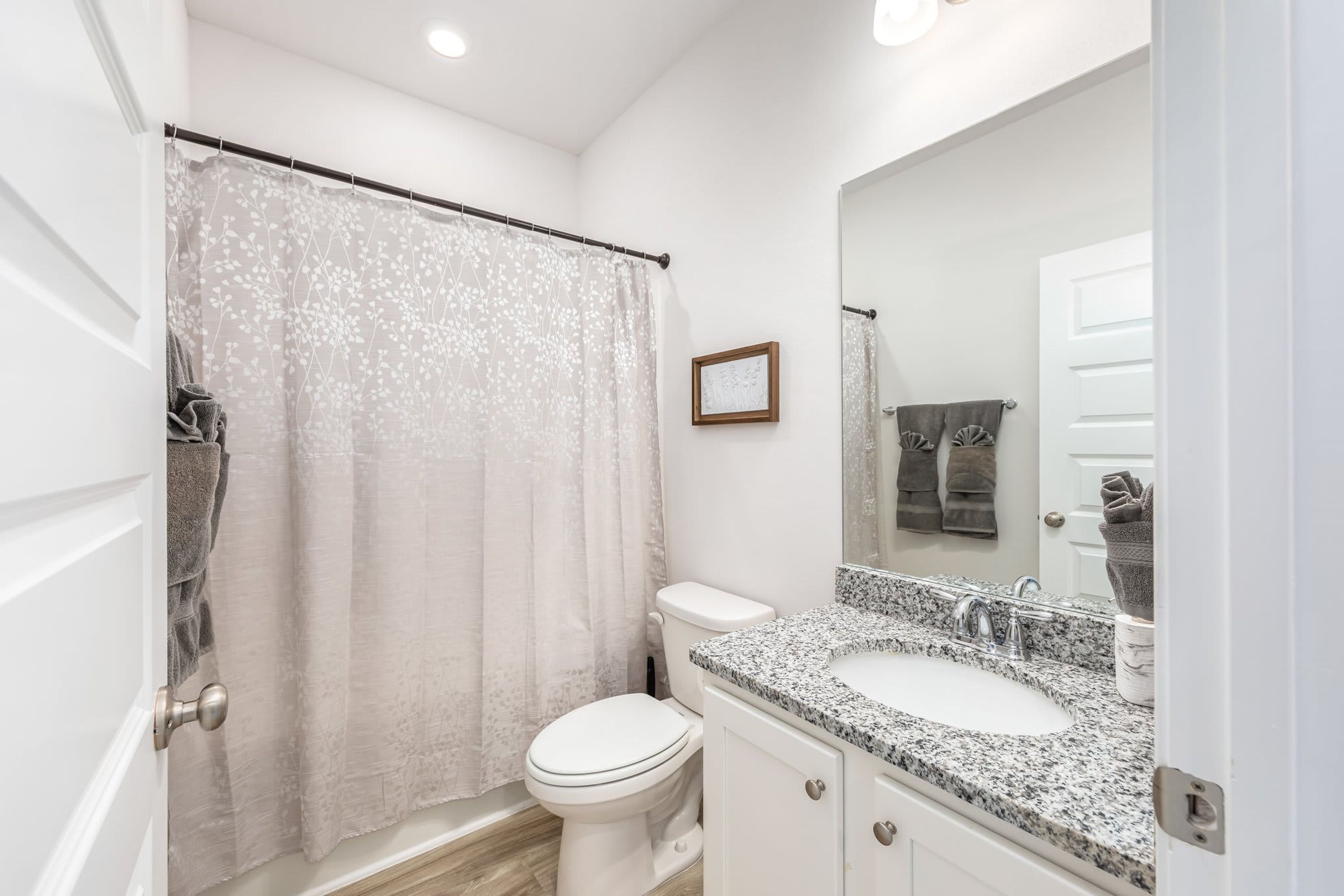 Une salle de bain équipée de toilettes, d’un lavabo et d’un rideau de douche.