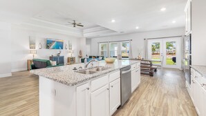 Una cocina amplia con encimera de granito, electrodomésticos de acero inoxidable y una isla grande.