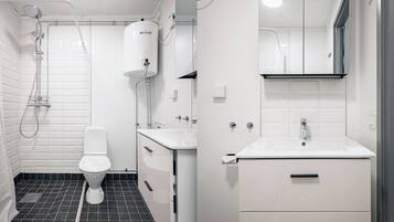 A modern bathroom with a toilet, shower, and sink.