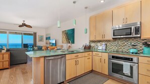 A modern kitchen with wooden cabinets, stainless steel appliances, and a large island. - Coastal Heights - Solana Beach Vacation Rental, Ocean Views, Pool, Pickleball (Solana Beach)