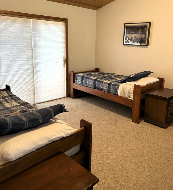 A room with two wooden beds, a small wooden table, and a window with blinds. - Hot tub, Pet friendly, directly across from GM Rec Center (Black Butte Ranch)