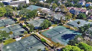 An aerial view of a sports complex with multiple tennis courts, surrounded by residential buildings and greenery. - 25 Springwood: First Floor, 1 Level, Walk to Beach (Hilton Head Island)
