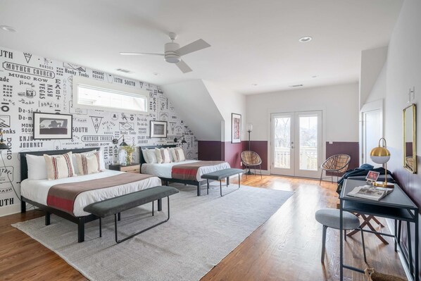 A modern bedroom with a sloped ceiling, a bed with a bench, a desk, and a chair. - Stylish Retreat Near Germantown (Nashville)