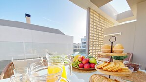 A breakfast setup with a pitcher of orange juice, a glass with lemon slices, a bowl of fruit, and a variety of bread on a table. - Exclusive Penthouse in Santa Rosalia Lake & Life Resort El Caribe on the Costa Calida (Torre-Pacheco)