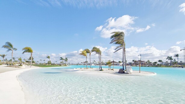 A beach resort with clear turquoise waters, white sand, and palm trees. - Exclusive Penthouse in Santa Rosalia Lake & Life Resort El Caribe on the Costa Calida (Torre-Pacheco)