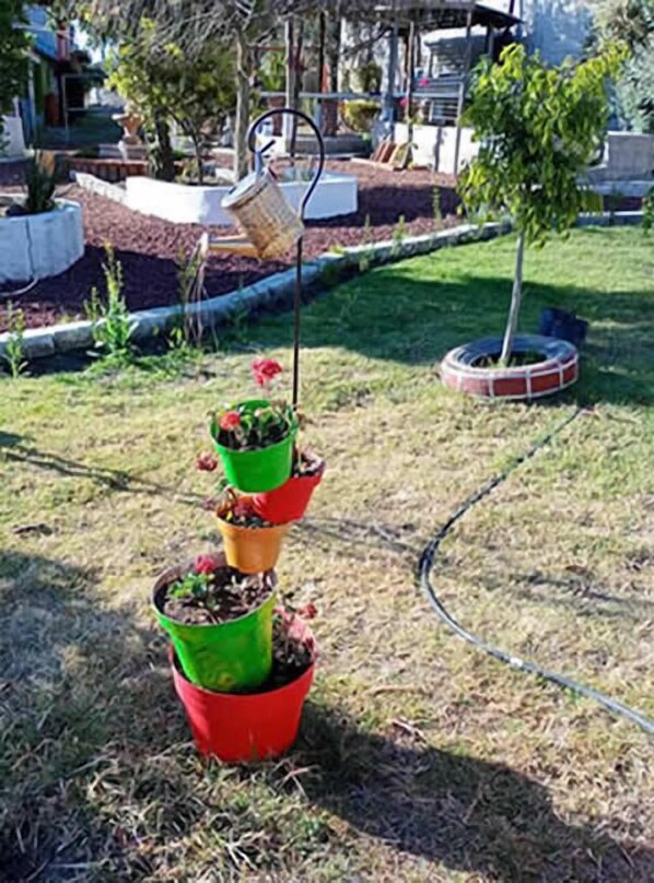 Un jardín con plantas en macetas dispuestas en una estructura escalonada.