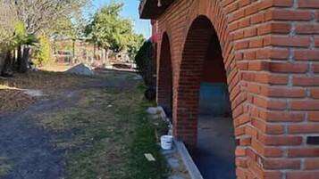 Un edificio de ladrillo con un corredor cubierto y cielo despejado.