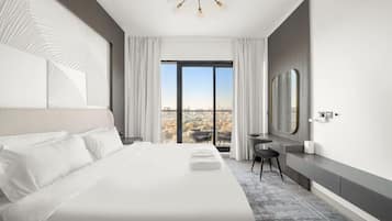 Une chambre d’hôtel moderne, dotée d’un grand lit, d’un bureau, d’une chaise et offrant une vue sur la ville par la fenêtre.