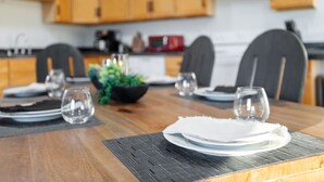 A dining table set with plates, glasses, and a centerpiece. - Fireside Haven | Hot Tub + Downtown Walkable (Custer)