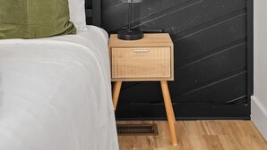 A bedroom with a bed, a nightstand, a lamp, and a framed picture on the wall. - Fireside Haven | Hot Tub + Downtown Walkable (Custer)