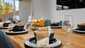 Une table à manger dressée avec des assiettes, des verres et des bougies, ce qui laisse supposer un repas formel.