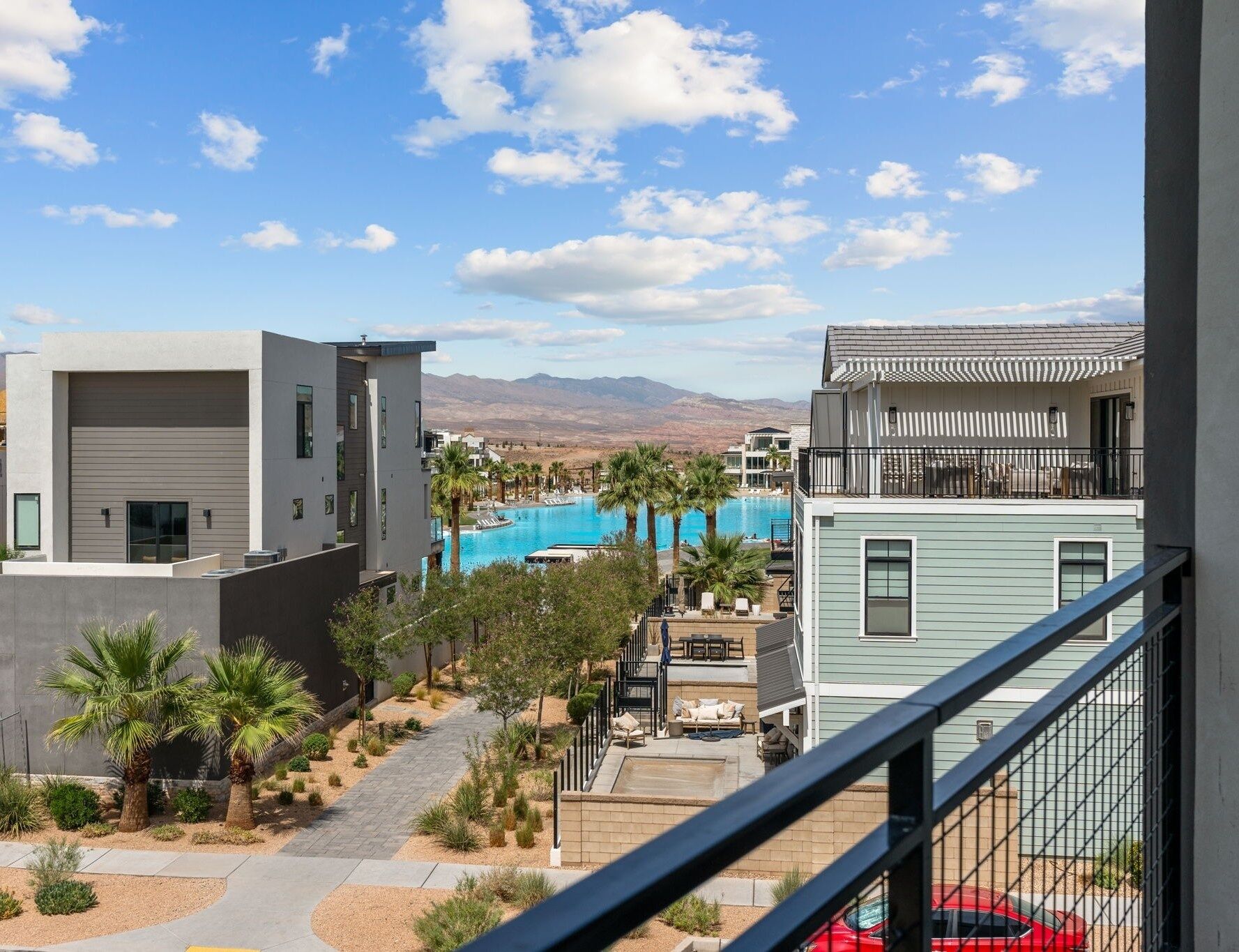 A residential area with modern houses, a swimming pool, and a mountain view.