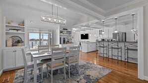 A spacious kitchen with white cabinetry, a central island, and pendant lighting. - NEWLY RENOVATED Sound Front Home with Dock in Downtown Beaufort, NC (Creek Watch) (Beaufort)