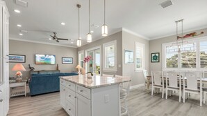 A modern kitchen with a central island, white cabinetry, and pendant lighting. - ARTIST HOUSE ~ Canal Front 4 BR/3.5 Ba Home w/ Pool & Ocean and Gulf Access! (Cudjoe Key)