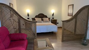 A bedroom with a bed, wooden furniture, and a staircase. - Hotel A Posada (Tembleque)
