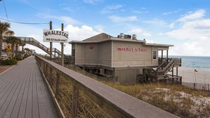 A beachside restaurant named Whale's Tail with a wooden boardwalk leading to it.