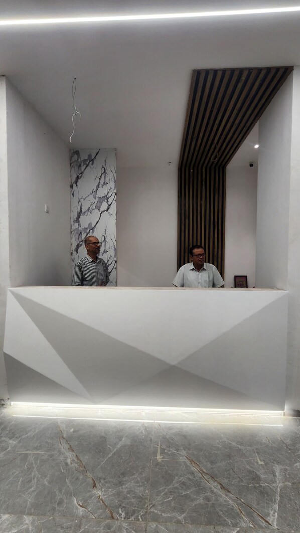 Una recepción con diseño moderno, pared de mármol y panel de madera a rayas.
