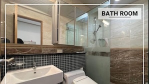 A bathroom with a sink, toilet, and glass shower enclosure.