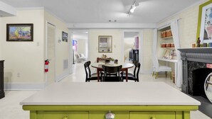 Een moderne keuken met een centraal eiland, een zithoek met stoelen en een open haard.