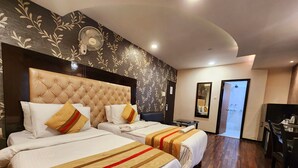 A hotel room with two beds, a large mirror, a TV, and a wooden floor. - HOTEL HOUSEZ43 (Kolkata)