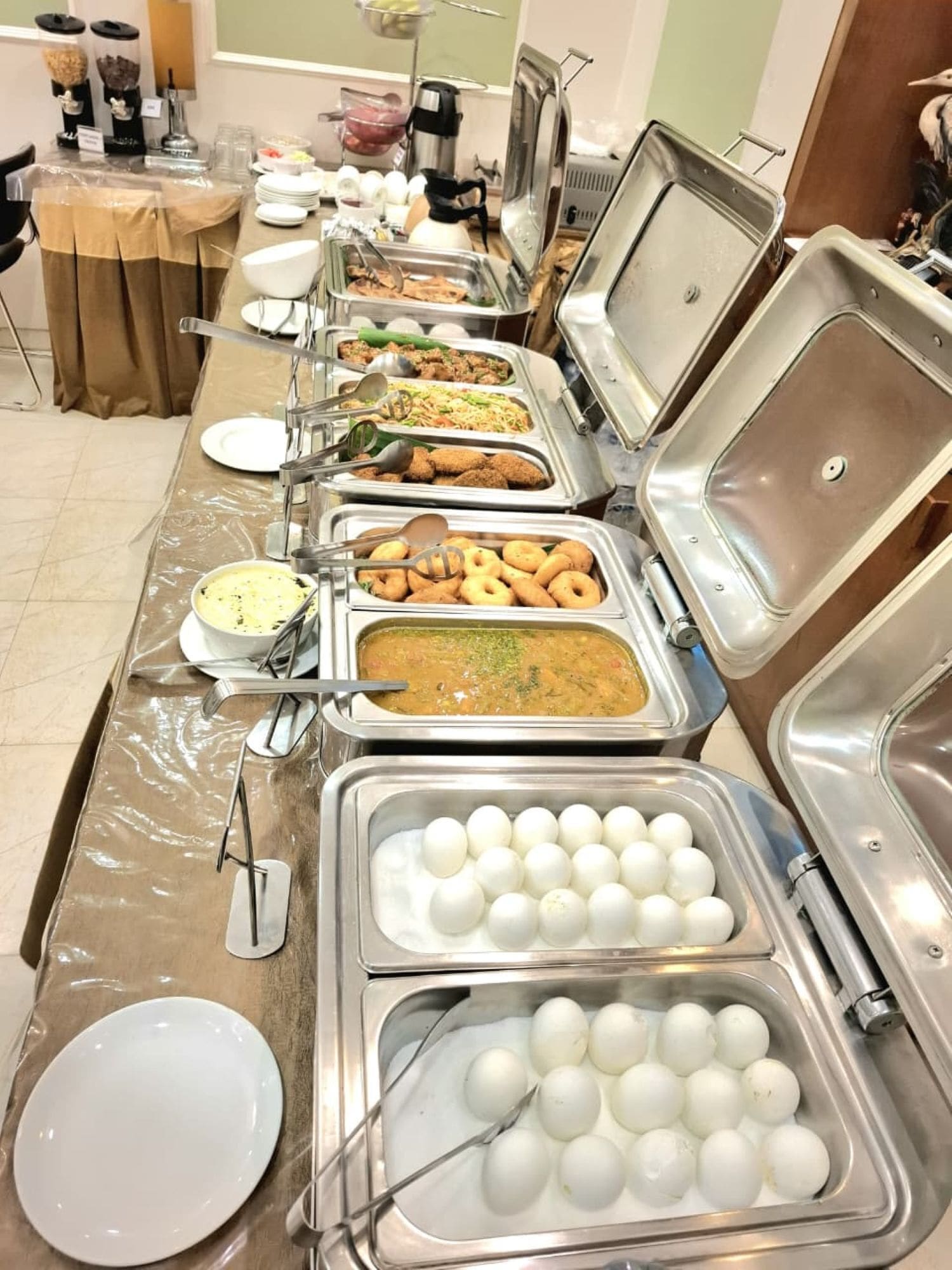 Un lungo tavolo del buffet con diversi cibi e posate.