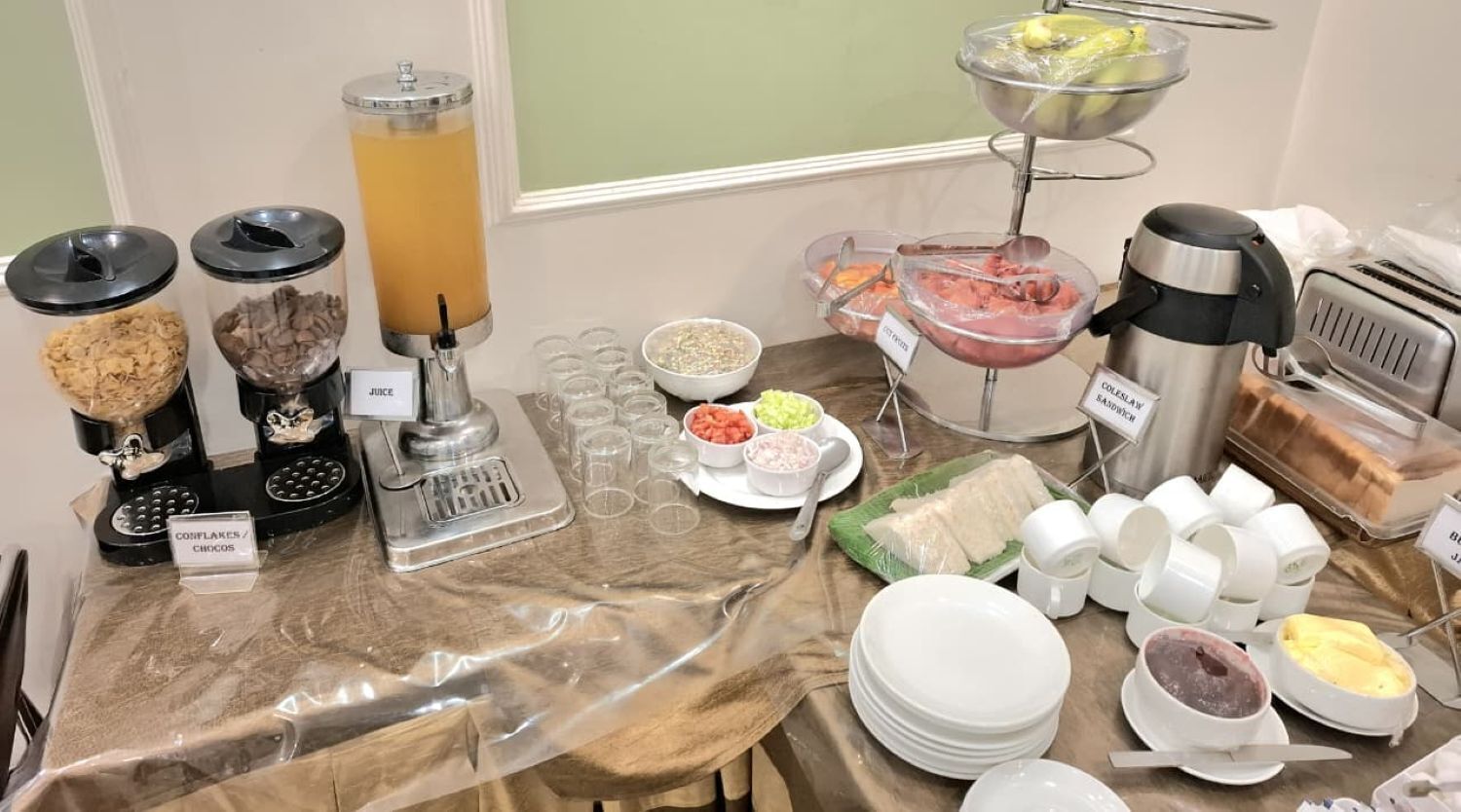 A buffet setup with various food items and a coffee station.