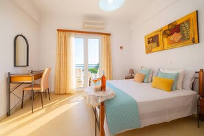 Habitació d'hotel amb llit, escriptori, cadira, taula i làmpada, i un quadre a la paret.