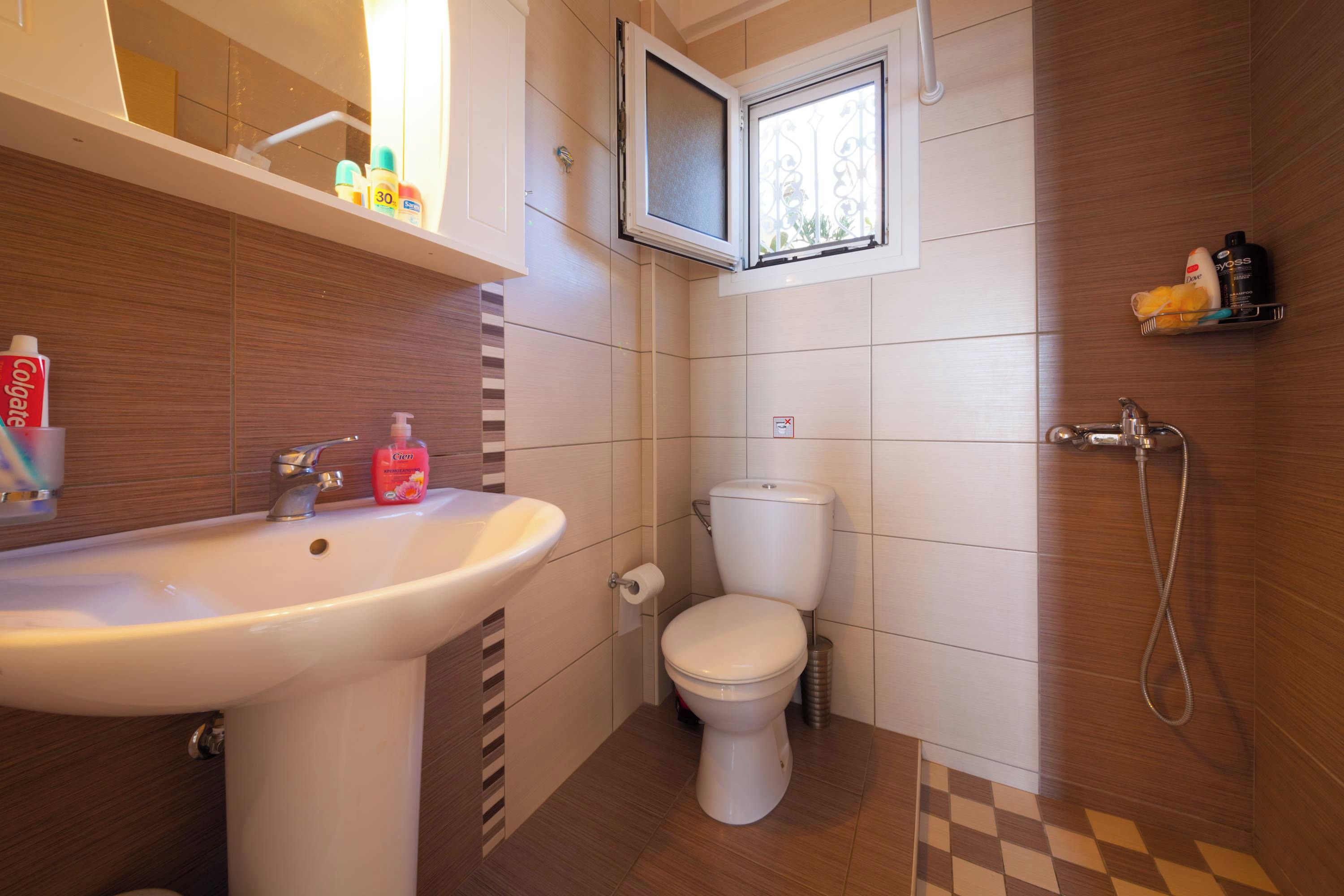 A bathroom with a sink, toilet, and shower.
