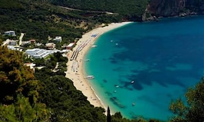 Eine Küstenlandschaft mit Strand, Booten und Gebäuden.
