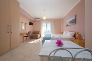 Ein Hotelzimmer mit Bett, Schreibtisch, Stuhl, Esstisch und Fernseher.