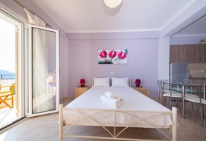 Ein Schlafzimmer mit einem Bett, zwei Nachttischen, einem Gemälde und Blick ins Freie.