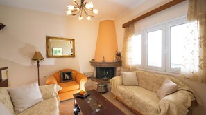 A living room with a fireplace, two sofas, a chair, and a mirror.