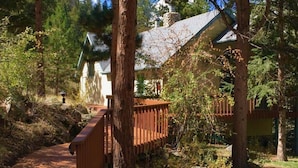 A wooden deck leading to a house surrounded by trees. - Chiming Bells Suite at RiverSong Inn in Estes Park - Riverside in Rocky Mountain National Park (Estes Park)