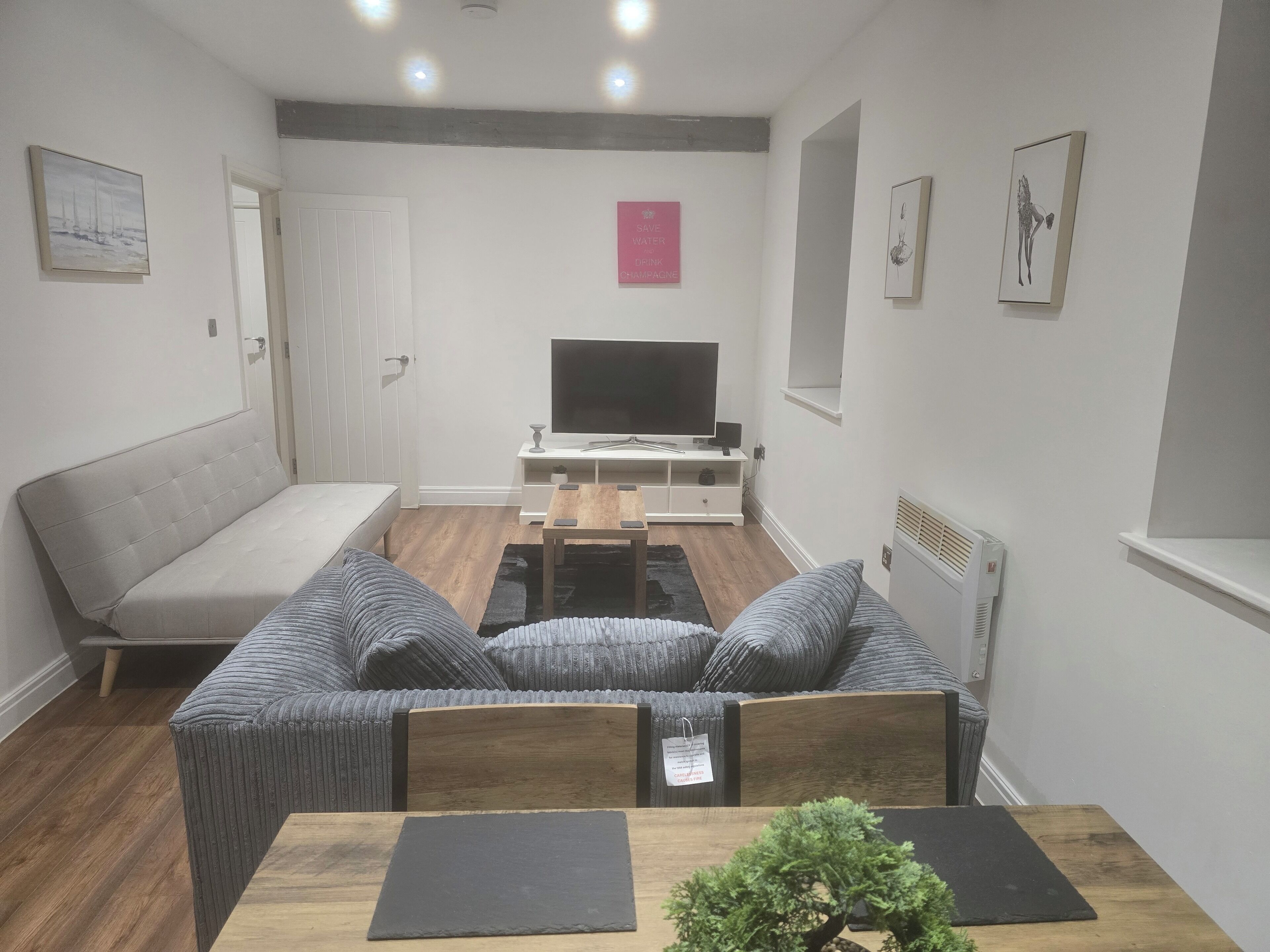Una sala de estar moderna con sofá, una mesa de centro y televisor.