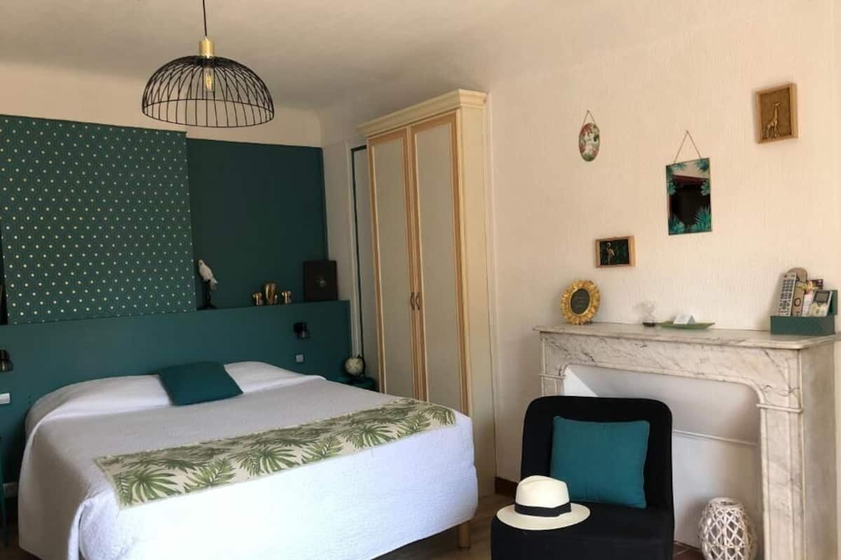 Quarto com duas camas, lareira e uma cadeira.