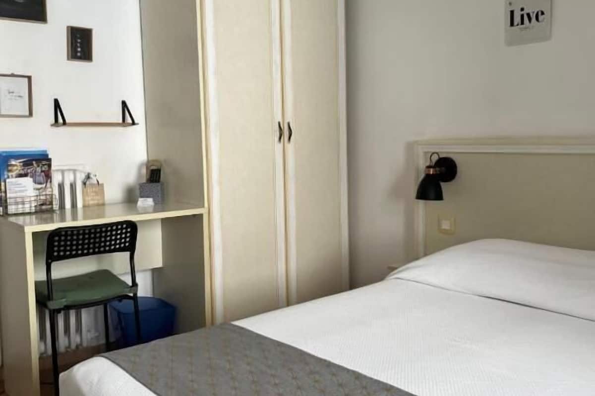 Quarto com cama, guarda-roupa, escrivaninha e cadeira.