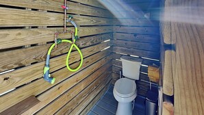 A wooden interior with a toilet and a shower area. - The Salty Dog at Copano Bay | Bay Views (Rockport)
