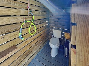 Un intérieur en bois comprenant des toilettes et un espace douche.