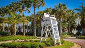 A sign for Seacrest Beach with a white structure and a ladder.